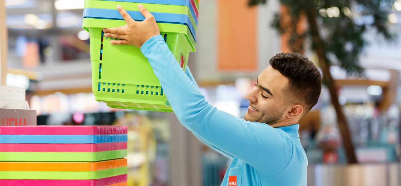 Jongen stapelt manden, in een winkel