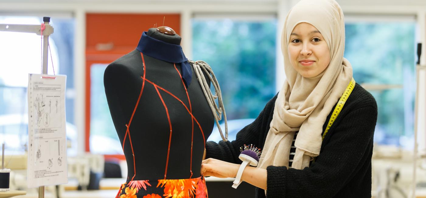 Studente past kleding op een paspop