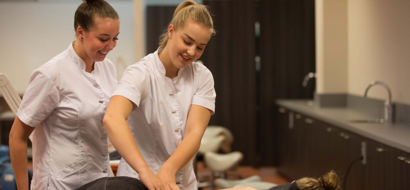 Studente geeft cliënt een rugmassage