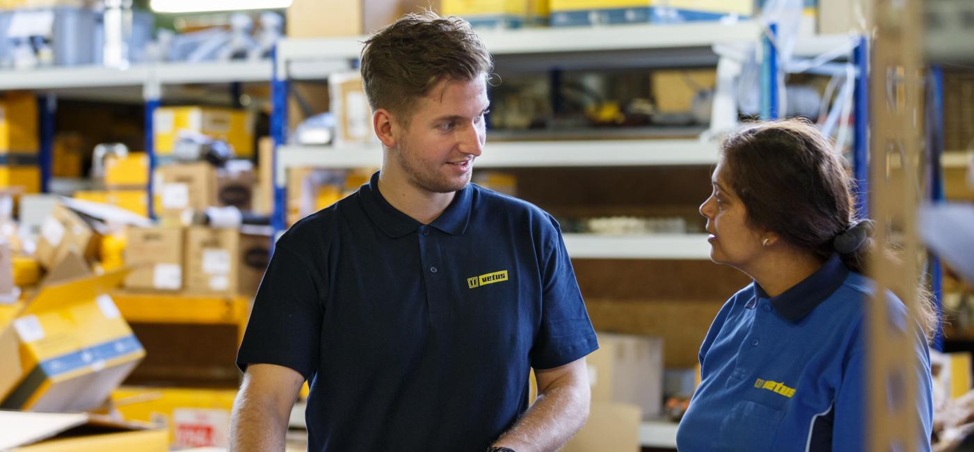 Jongen en vrouw in magazijn, tafel gesprek