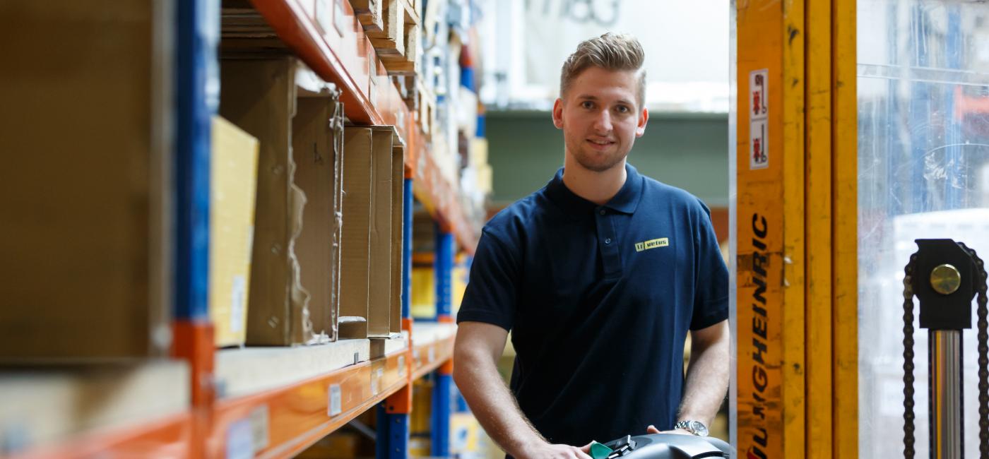 Jongen in magazijn tussen stellingen