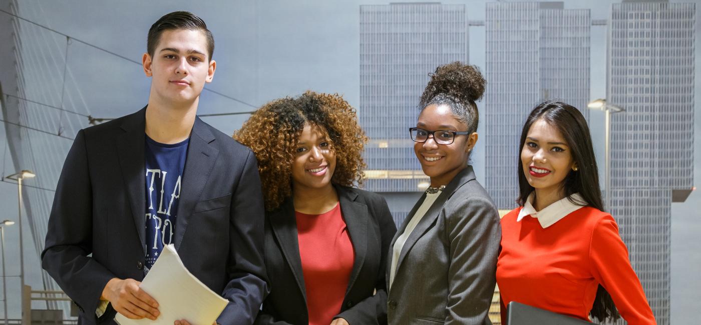 Vier studenten kijken in camera. Een man en drie vrouwen.