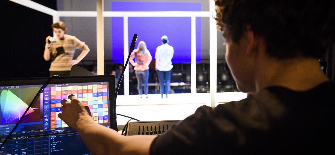 Lichttechnicus regelt het licht op het podium bij voorstelling