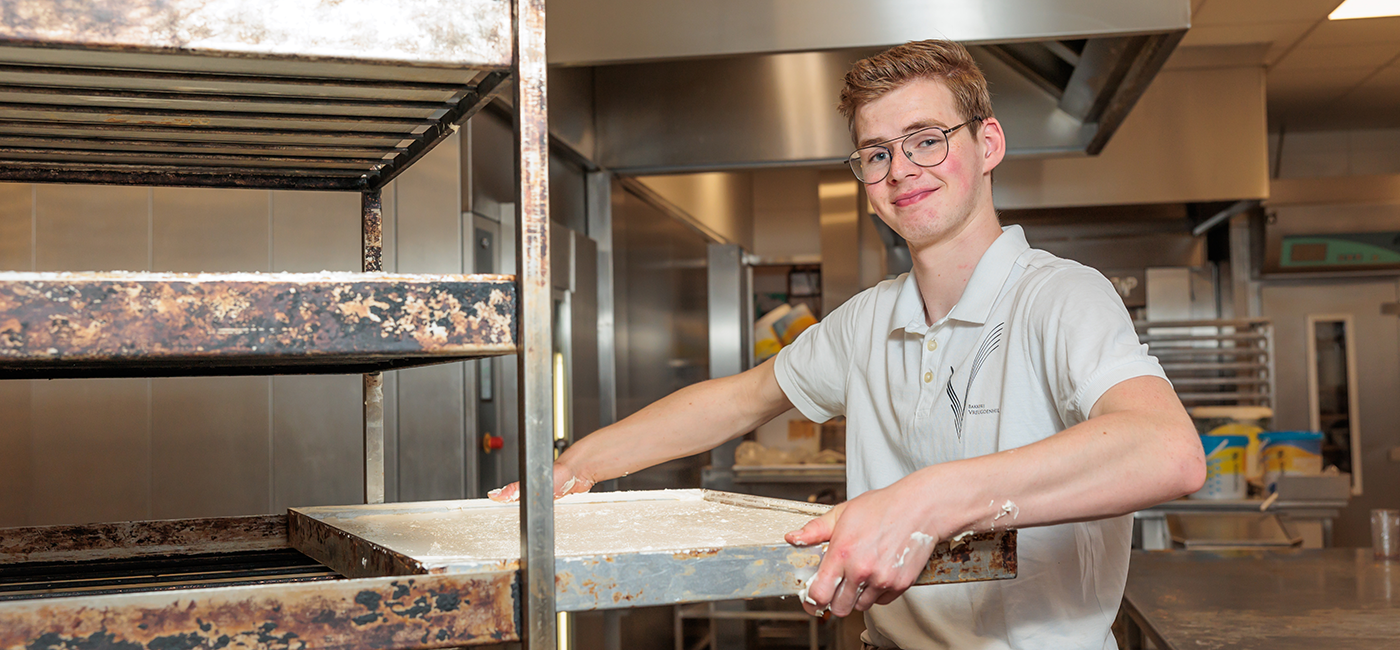 Student met bakplaat in de handen