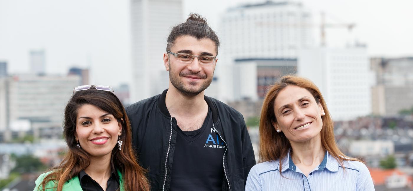 3 mensen, twee vrouwen en een man kijken blij in de camera