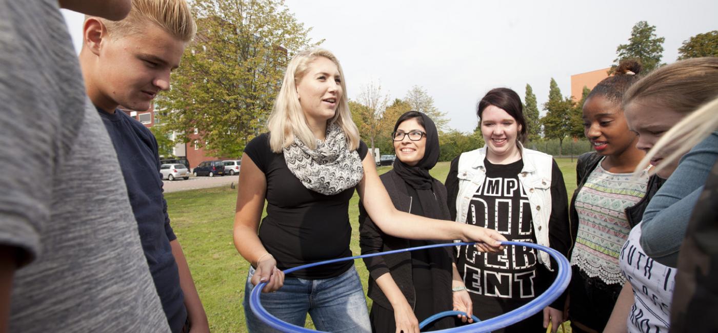 Jonge vrouw legt spel met hoepel uit