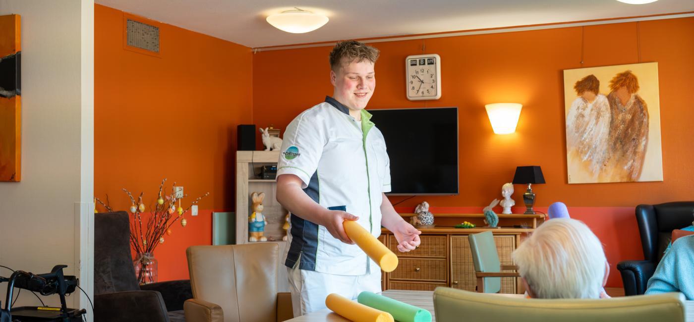 Huiskamer met medewerker en ouderen