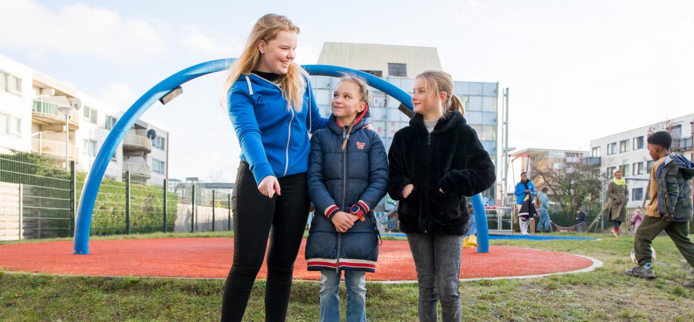 Student met twee kinderen in speeltuin