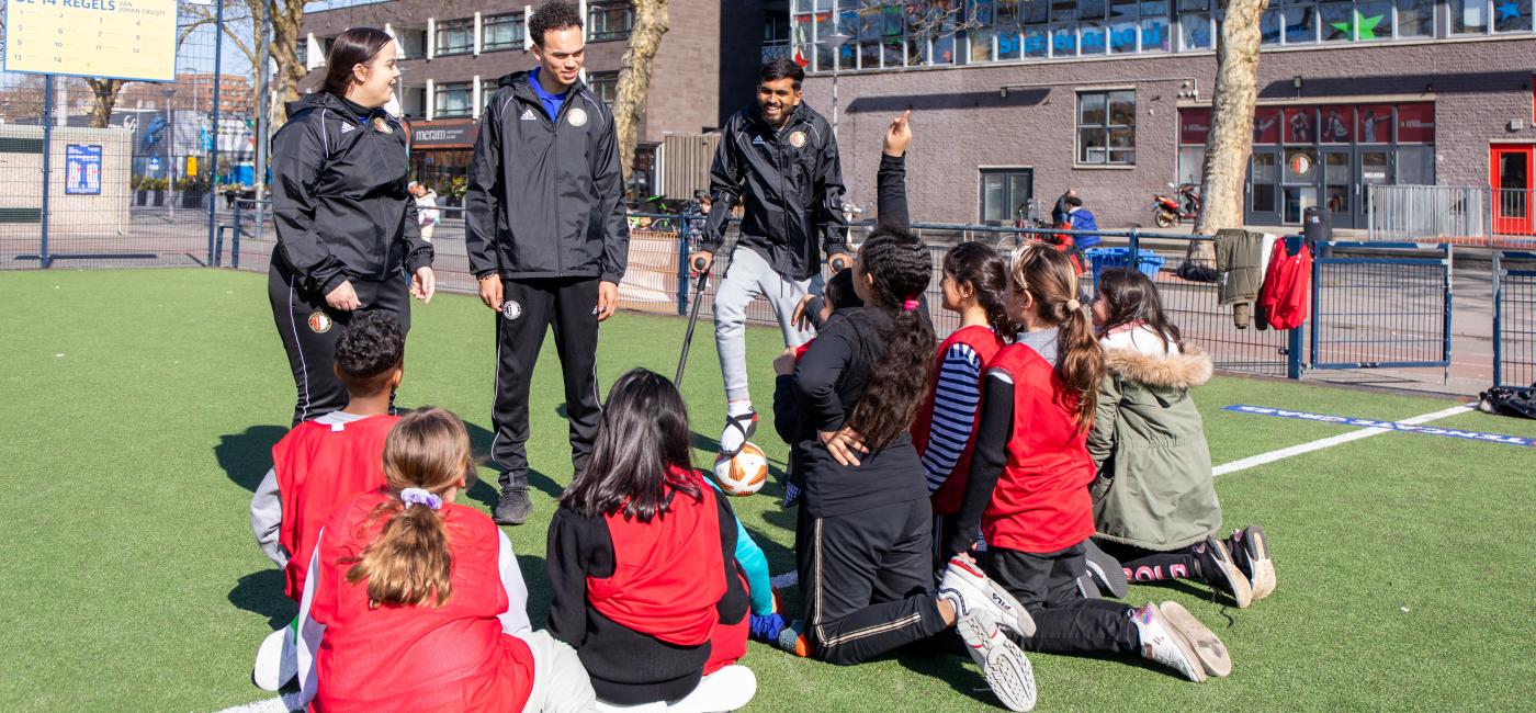 kinderen met trainers op voetbalveld