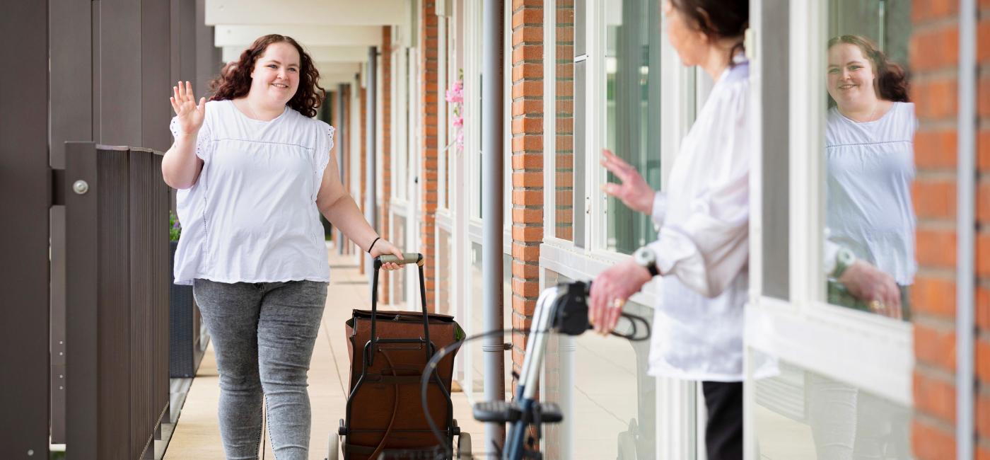 Vrouw doet boodschappen voor oudere vrouw