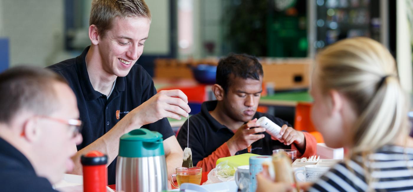 Mensen in een woongroep zitten aan de eettafel