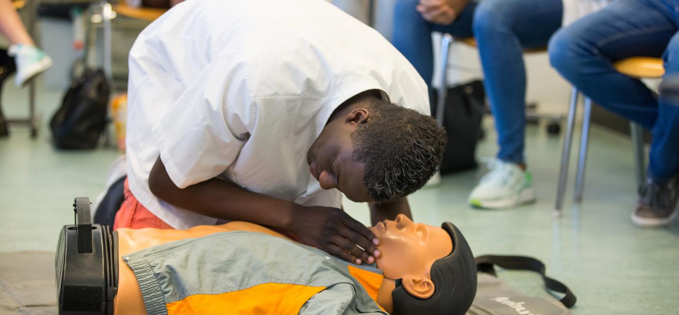 Jonge man oefent reanimatie op een pop